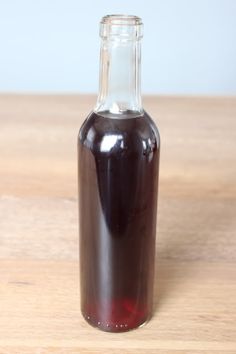 a glass bottle filled with liquid sitting on top of a wooden table