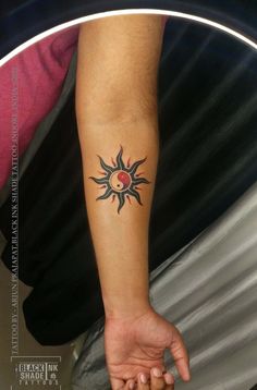 a person's arm with a tattoo on it and the sun in the middle