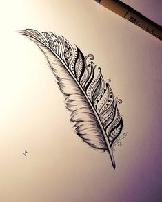 a drawing of a feather on a piece of paper with a pen next to it