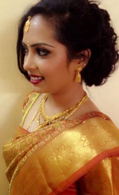 a woman in an orange and gold sari