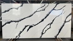 white marble with black veining on the top and bottom, displayed in a warehouse