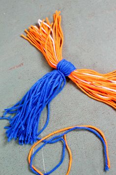 an orange and blue tassel is laying on the ground