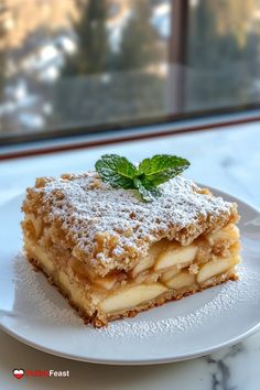 a piece of dessert sitting on top of a white plate next to a glass window