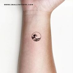 a small tattoo on the wrist of a person with a wave coming out of it