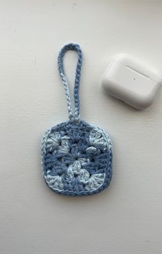 a crocheted blue and white object next to an air freshener dispenser