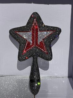 a red and white star on top of a black object with lights in the background