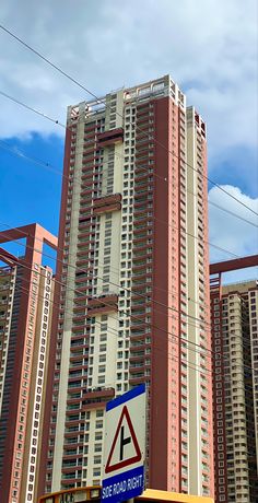 a tall building with many windows and signs on it's sides in front of other buildings