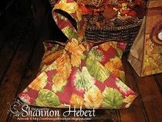 a bag sitting on top of a wooden floor next to a basket filled with autumn leaves