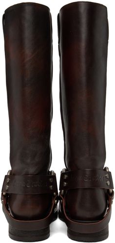 Knee-high buffed leather boots in brown. · Pull loops at collar · Ankle strap · Square toe · Logo embossed at back strap · O-ring at sides · Stacked leather heel with rubber injection · Buffed leather lining · Antiqued gunmetal-tone metal hardware · Heel: H1.5 Available exclusively at SSENSE. Supplier color: Dark Brown Stirrups, Boots Knee, Dark Brown Leather, Metal Hardware, Back Strap, O Ring, Leather Heels, High Boots, Knee High Boots