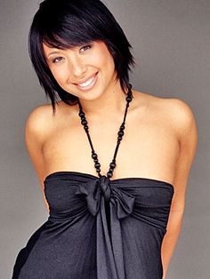 a woman wearing a black dress and smiling