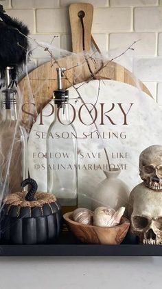 halloween decorations with spooky written on the sign and skulls sitting in front of it