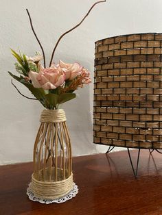 a vase with flowers in it sitting on a table next to a woven piece of material