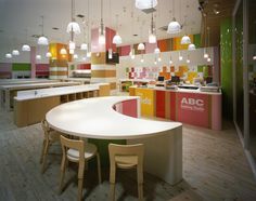 the interior of an office with brightly colored walls and tables, chairs, and counters