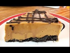 a piece of chocolate cheesecake on a white and red plate with a wooden table in the background