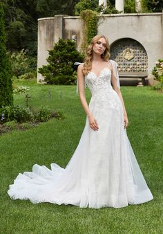 a woman in a wedding dress standing on the grass