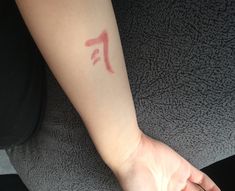 a person's arm with a tattoo on it that has the letter f painted on it