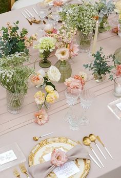 the table is set with flowers and place settings