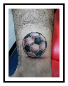 a man's foot with a soccer ball tattoo on it