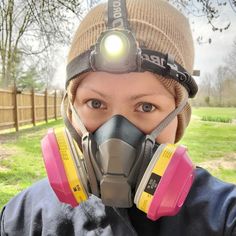 a woman wearing a gas mask with headlamps and a light on her face