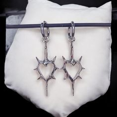 Gothic Thorn Heart Earrings - Korean Punk Charms for Women, Hip Hop Grunge Jewelry 📦 Processing Time: 5-7 days ✈ Shipping Time: 6-10 days Shipping: Free international shipping on all orders! Customer Satisfaction Guaranteed: If your earrings arrive damaged, we offer a full refund or replacement. Add a touch of rebellion to your jewelry collection with these striking Gothic Thorn Heart Earrings. Perfect for yourself or as a gift for someone who loves bold, alternative fashion! Questions? Feel fr Edgy Pierced Earrings For Concerts, Edgy Heart-shaped Jewelry For Alternative Fashion, Punk Style Earrings For Concert, Punk Metal Earrings For Concerts, Silver Punk Earrings For Concert, Edgy Hoop Earrings As A Gift, Punk Style Metal Earrings For Concert, Punk Heart-shaped Earrings, Punk Dangle Earrings