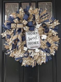 a blue and white wreath with the words home sweet home written on it in front of a black door