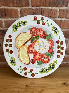 a white plate with tomatoes, cheese and bread on it next to a brick wall