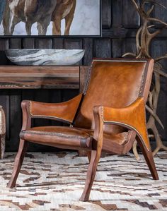 a brown leather chair sitting on top of a rug