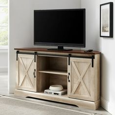 a flat screen tv sitting on top of a wooden entertainment center