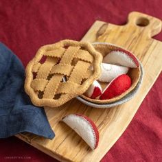 a wooden cutting board topped with two pies