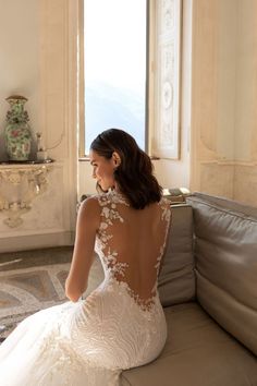 a woman in a wedding dress sitting on a couch