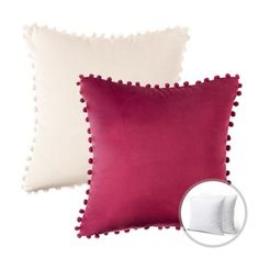 two pillows with pom - poms on them, one in white and the other in pink