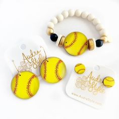 two bracelets with baseball charms on them sitting next to a tag that says add style