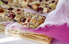 some kind of granola bar sitting on top of a wooden board next to a pink cloth