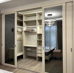 an empty bedroom with mirrored closet doors and shelves on the wall next to a bed