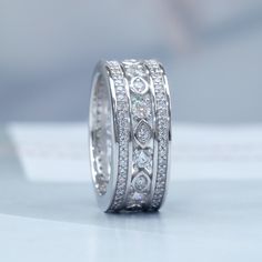 a close up view of a wedding ring with diamonds on the sides and in the middle