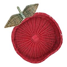 an apple shaped wicker basket with a leaf on the top and bottom, sitting in front of a white background