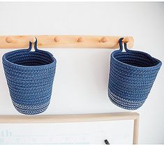 two blue baskets are hanging on a coat rack