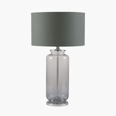 a clear glass table lamp with a grey shade on the base and a gray linen lampshade