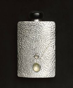 a silver flask with two buttons on it