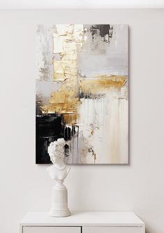 an abstract painting hangs on the wall above a white cabinet and vase with flowers in it