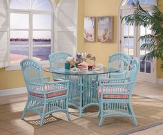 a dining room table with chairs and a potted plant in front of the window