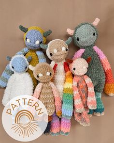 a group of knitted stuffed animals sitting next to each other on a brown background