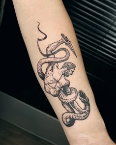 a tattoo on the arm of a person with a snake and an arrow in it