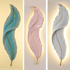 three different types of decorative wall hangings with light colored feathers on the sides and bottom