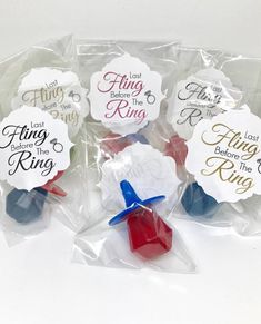 four plastic tags with different sayings on them in cellophane bags, one is red white and the other blue