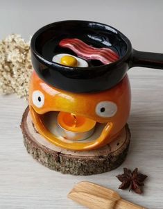 an orange and black cup with food in it sitting on top of a wooden stand