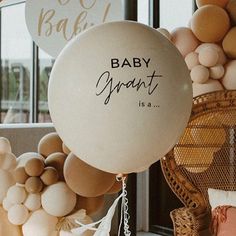 there is a balloon that says baby grant next to some balloons and other decorations on the wall