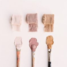 there are five brushes with different shades of paint on them, one is pink and the other is brown