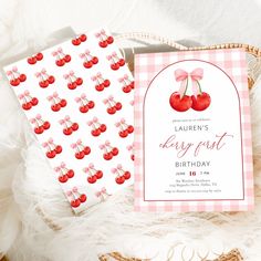 the cherries first birthday party is set up with pink gingham paper and cherry themed napkins