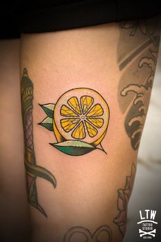 an orange tattoo on the side of a woman's thigh